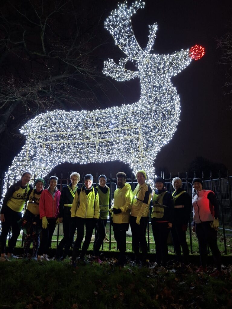 Runners in front of very large Reindeer Christmas lights frame
